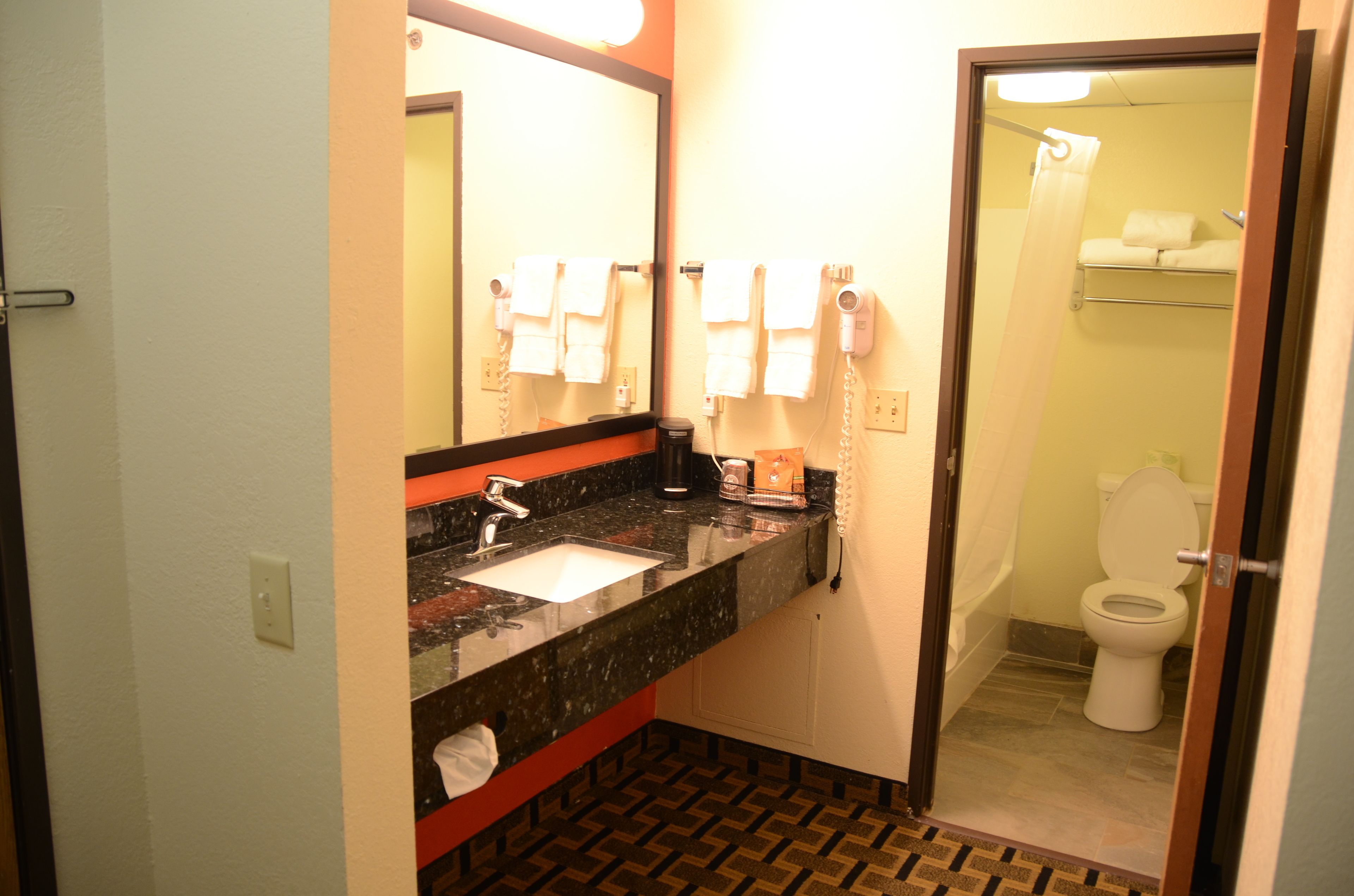 A bathroom with a sink, mirror, and toilet.