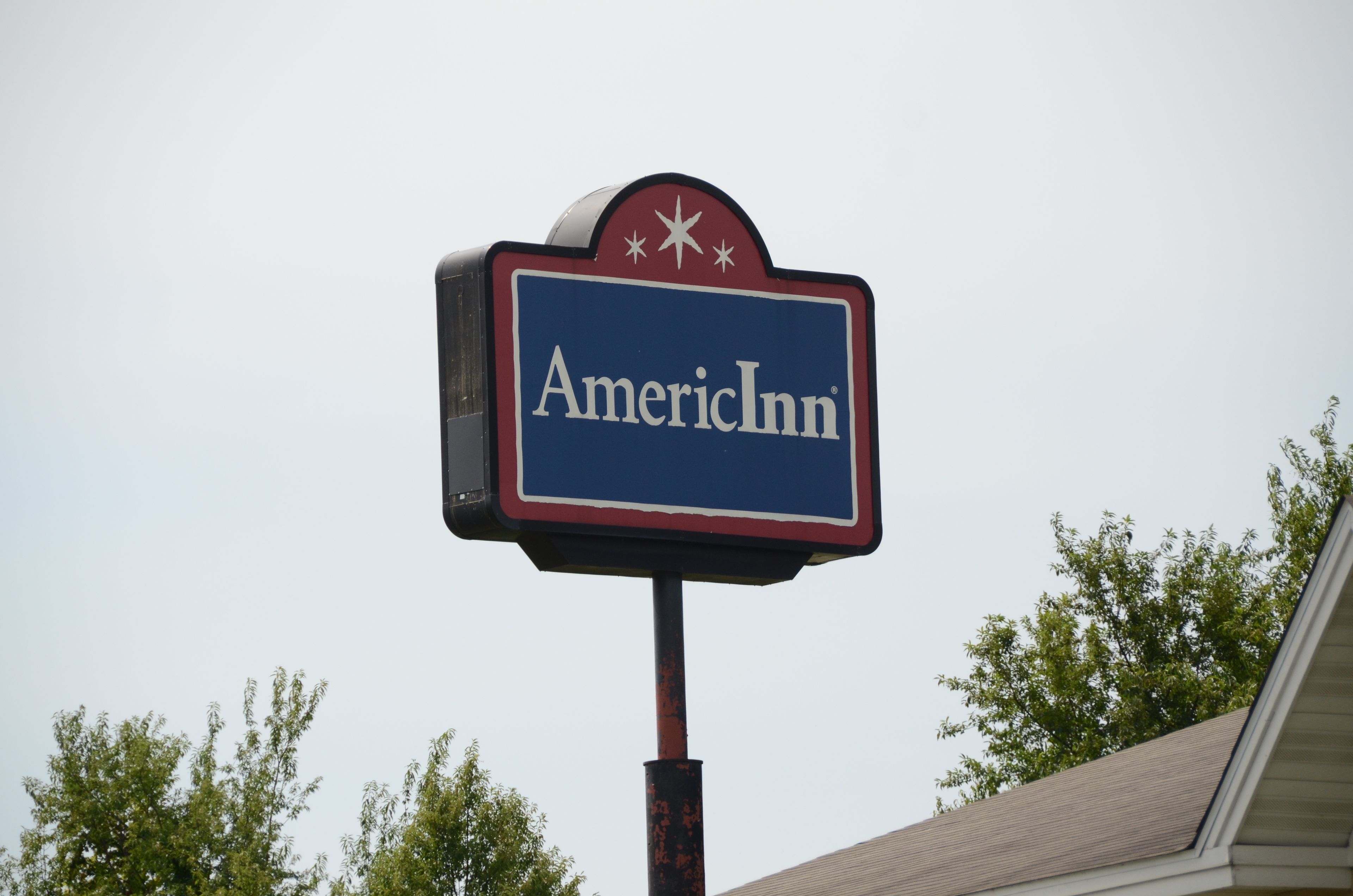 A sign for AmericInn with a star and flag design.
