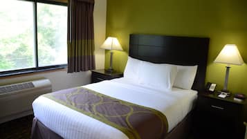 A hotel room with a large bed, two bedside lamps, a nightstand with a phone, and a window with curtains.