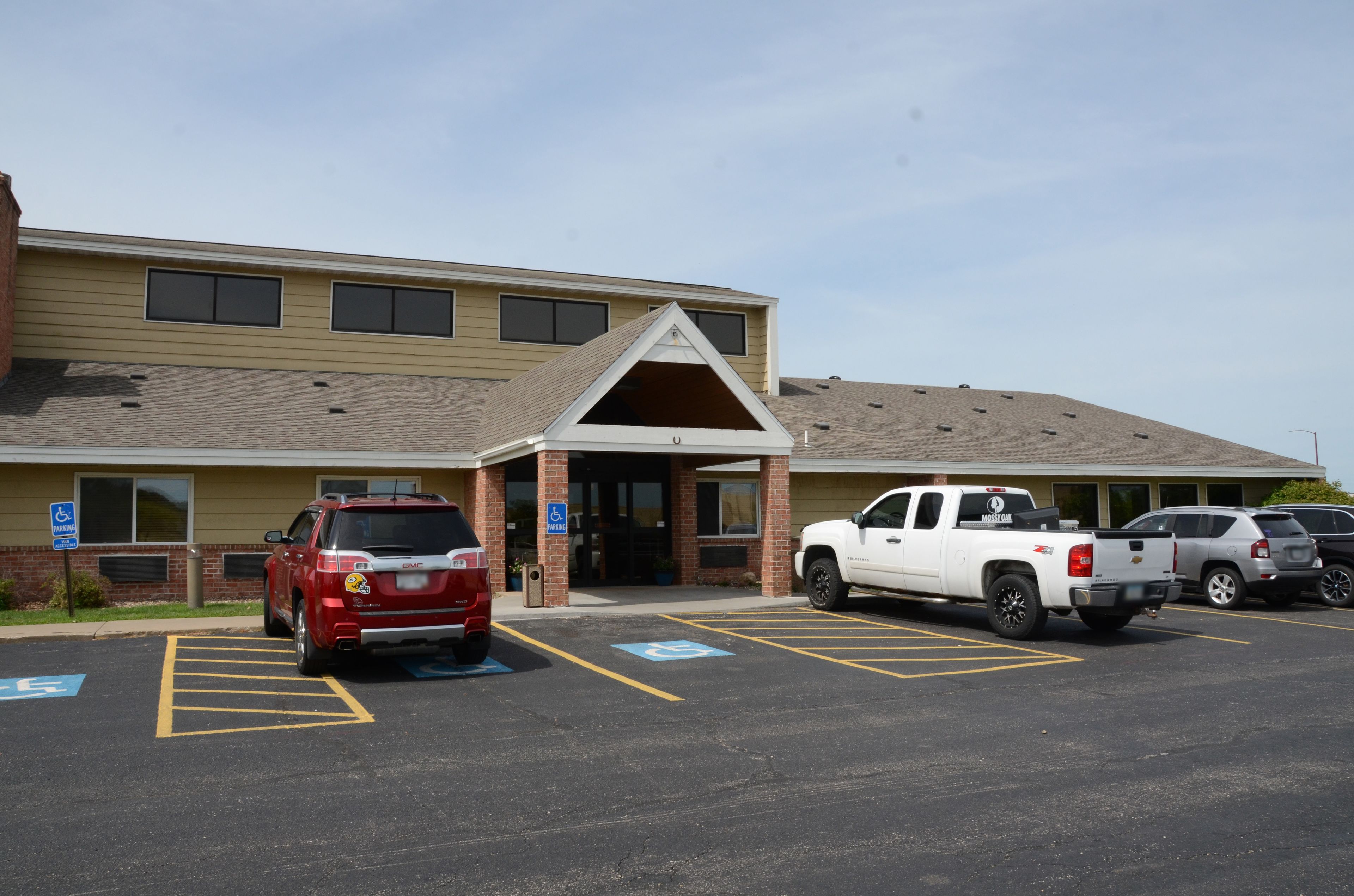 A building with a parking lot, including marked handicapped spaces and a fire hydrant.
