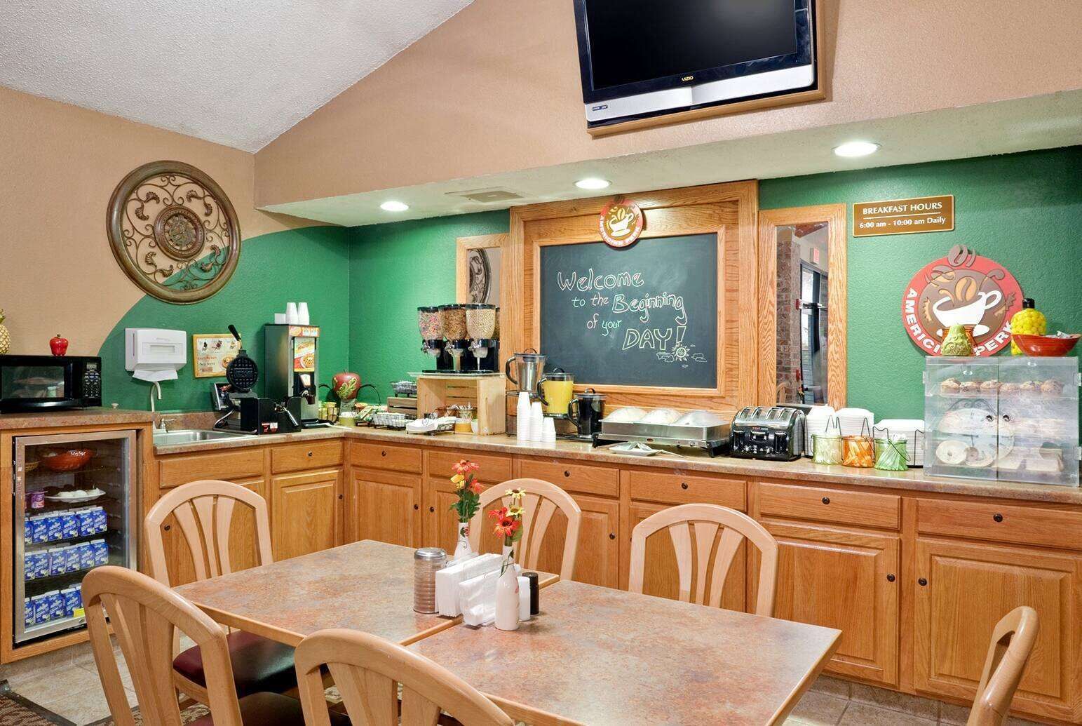 Un espace dédié au petit-déjeuner, avec un tableau noir, une machine à café et divers produits pour le petit-déjeuner disposés sur le comptoir.