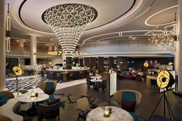 A spacious lobby with a large chandelier, multiple seating areas, and a bar. - Renaissance Shanghai Hongqiao (Shanghai)