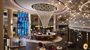 A modern hotel lobby with a central bar, seating areas, and a large decorative light fixture. - Renaissance Shanghai Hongqiao (Shanghai)