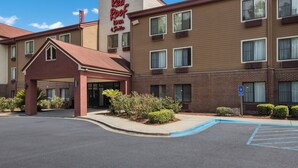 A Red Roof Inn with a brick facade, multiple windows, and a parking lot with a handicapped accessible sign.