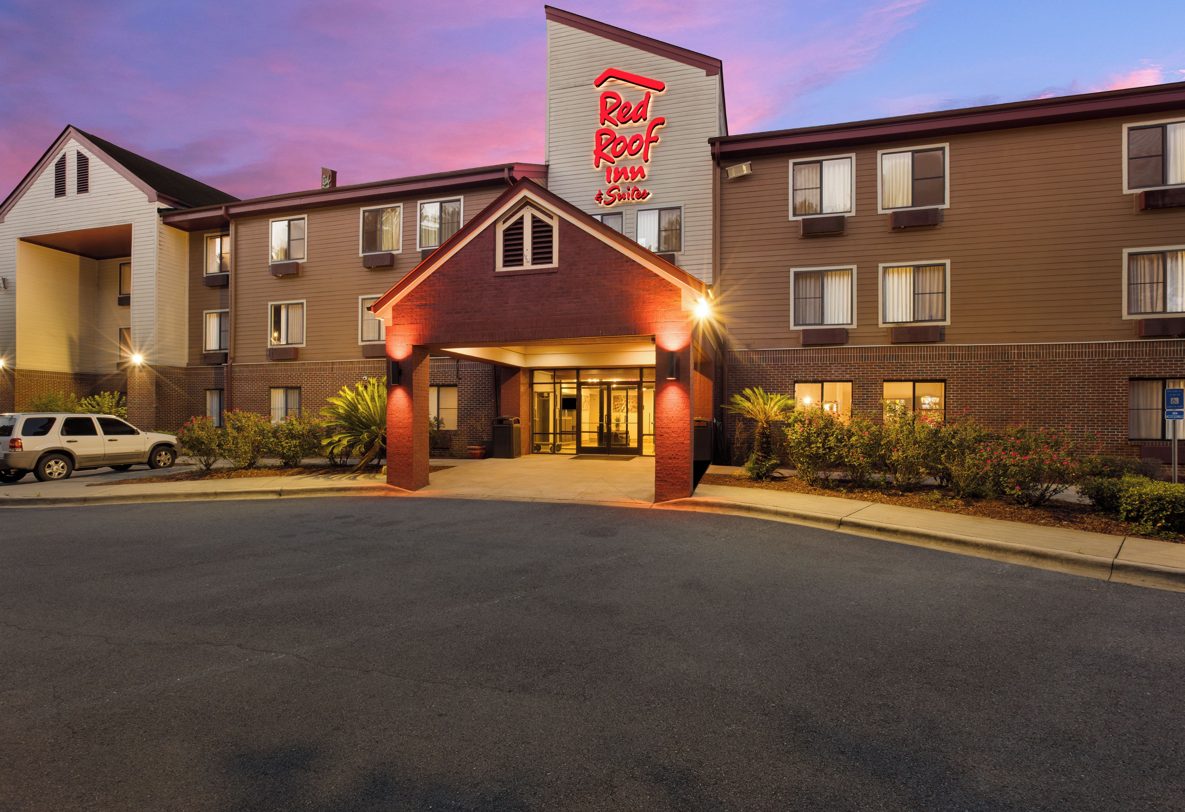 Un Red Roof Inn con facciata in mattoni, numerose finestre e un ingresso con cancello.
