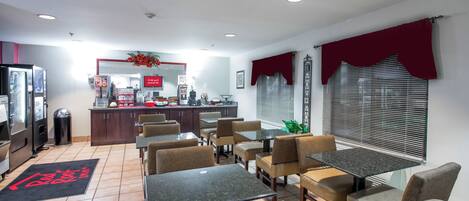 Un restaurant doté d’un comptoir, d’un espace pour s’asseoir et d’une grande fenêtre équipée de stores.