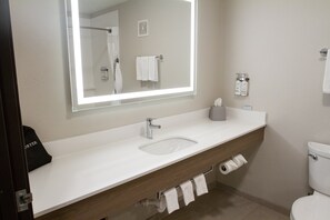 A bathroom with a white sink, a mirror, a towel rack, and a toilet.