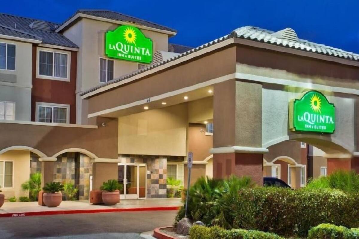 A hotel with a prominent 'La Quinta Inn & Suites' sign, a covered entrance, and a parking lot.