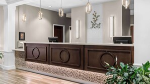 A reception area with a modern design, featuring a reception desk, pendant lighting, and a decorative wall piece. - Best Western Gettysburg (Gettysburg)