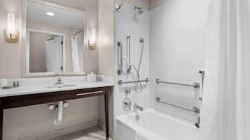Un baño moderno con lavamanos blanco, espejo y zona de ducha.