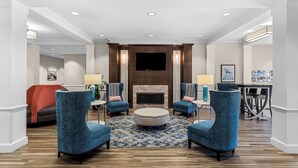 A spacious lobby with a fireplace, blue armchairs, and a patterned rug. - Best Western Gettysburg (Gettysburg)