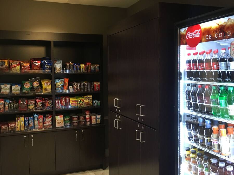 Myyntiautomaattialue, jossa on tarjolla välipaloja ja juomia, mukaan lukien Coca-Cola-automaatti.