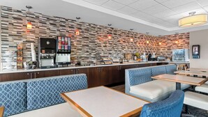 A modern restaurant with a patterned wall, seating areas, and a coffee station. - Best Western Gettysburg (Gettysburg)