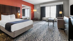 A hotel room with a large bed, a desk, a chair, a dresser, and a TV. - Best Western Gettysburg (Gettysburg)