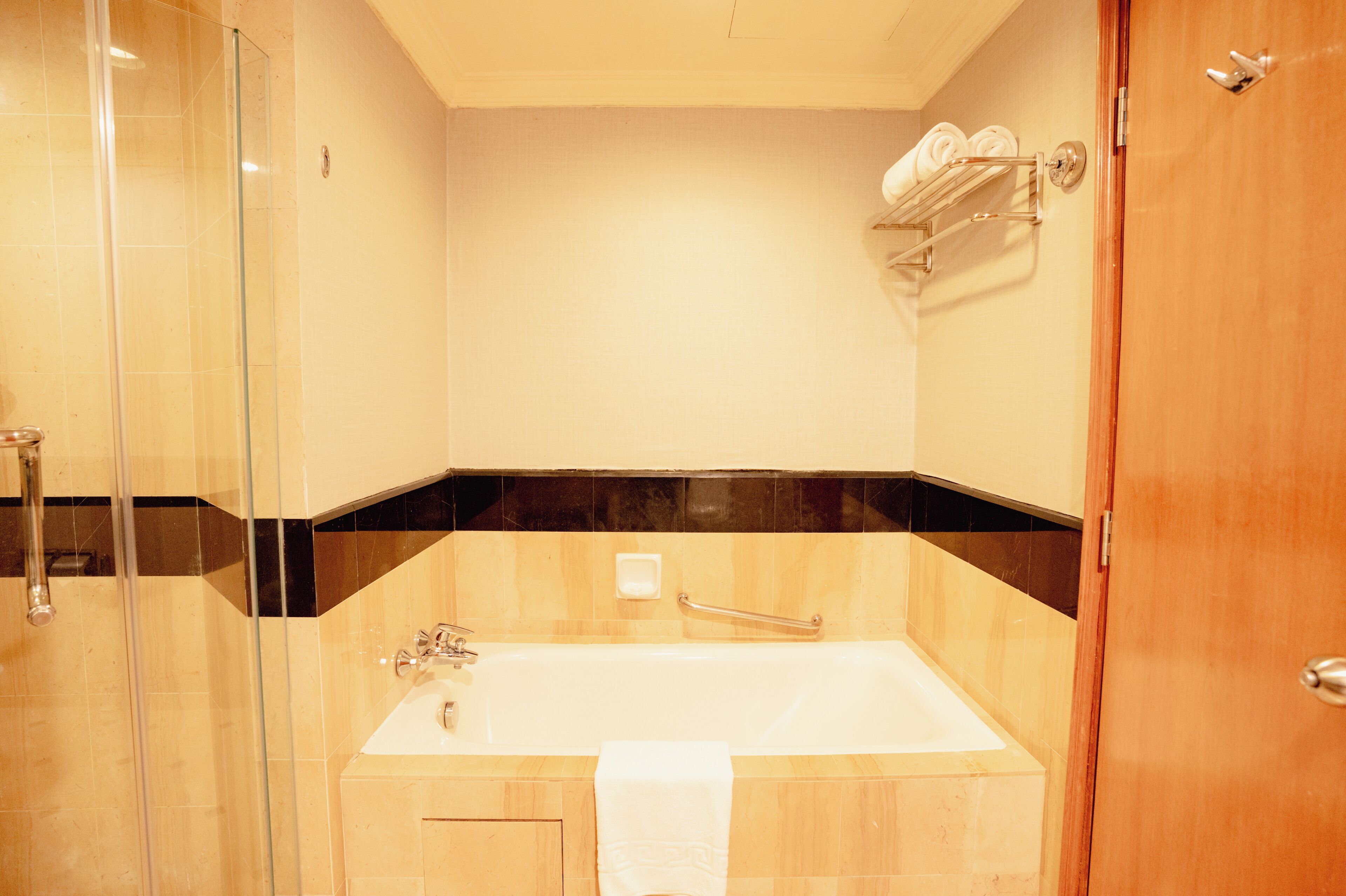 Un baño con cabina de ducha de vidrio, bañera y tocador de madera.