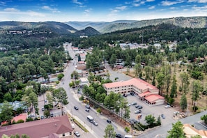 A town with a main road, buildings, and surrounding hills.