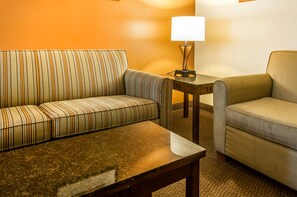 A room with a striped sofa, a plain sofa, and a small table with a lamp. - Comfort Inn & Suites Midtown (Ruidoso)
