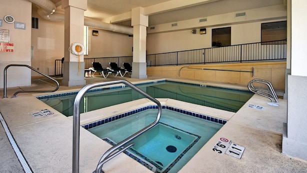 A pool area with two separate pools, each with a diving board and a lifeguard chair.