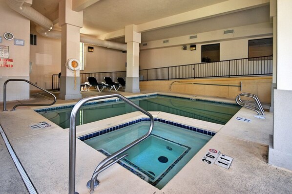 Un área de piscina con dos piscinas separadas, cada una con un trampolín y una silla para socorrista.
