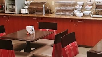 Un restaurante con mostrador, bufé y fotografías enmarcadas en la pared.