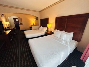 A hotel room with two beds, a desk, a chair, and a lamp. - Sylvania Inn & Suites Tigard Portland I-5 (Portland)