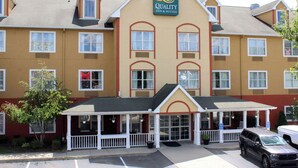 A hotel with a prominent sign, a covered entrance, and a parking lot. - Quality Inn & Suites Cincinnati Sharonville (Sharonville)