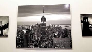 Un paisaje urbano con un rascacielos destacado, un puente y una masa de agua.