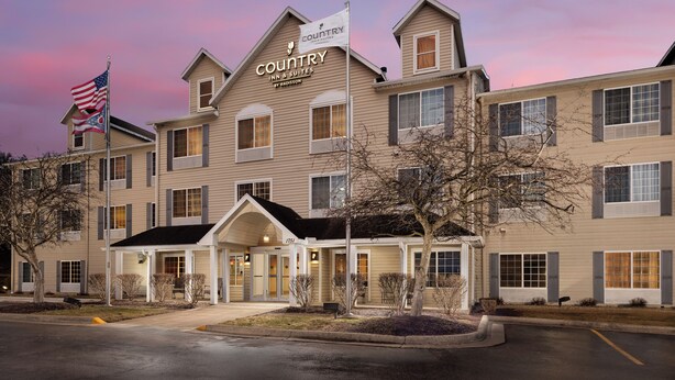 A hotel with a sign reading "Country Inn & Suites by Radisson" and an American flag. - Country Inn & Suites by Radisson, Springfield, OH (Springfield)