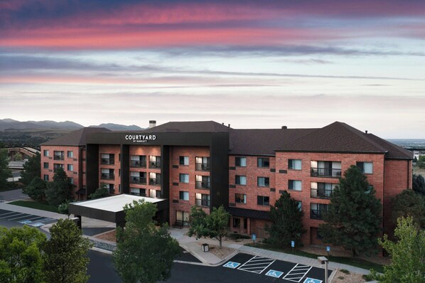 A Courtyard hotel with a brick facade, multiple balconies, and a parking lot with handicapped spaces. - Courtyard by Marriott Denver Golden/Red Rocks (Golden)
