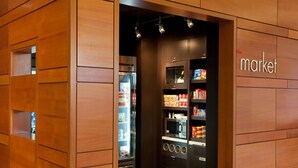 Een modern interieur met houten lambrisering, een gekoeld display en een magnetron.
