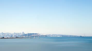 Une vue urbaine sur le front de mer, avec un pont imposant et une ligne d’horizon lointaine.