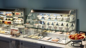 Buffet amb diverses platelles de menjar i bols de iogurt.