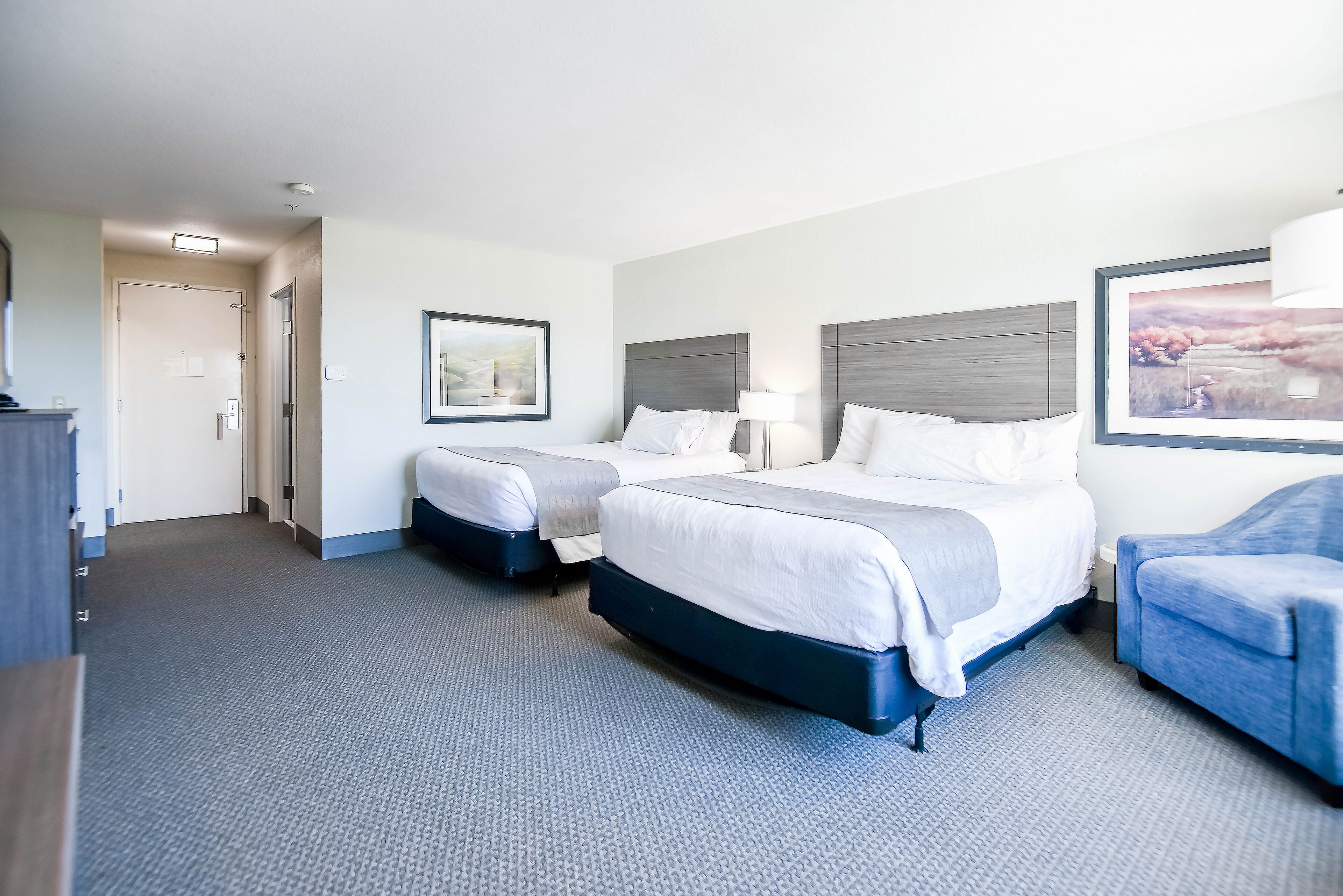 Een hotelkamer met twee bedden, een bureau en een stoel.