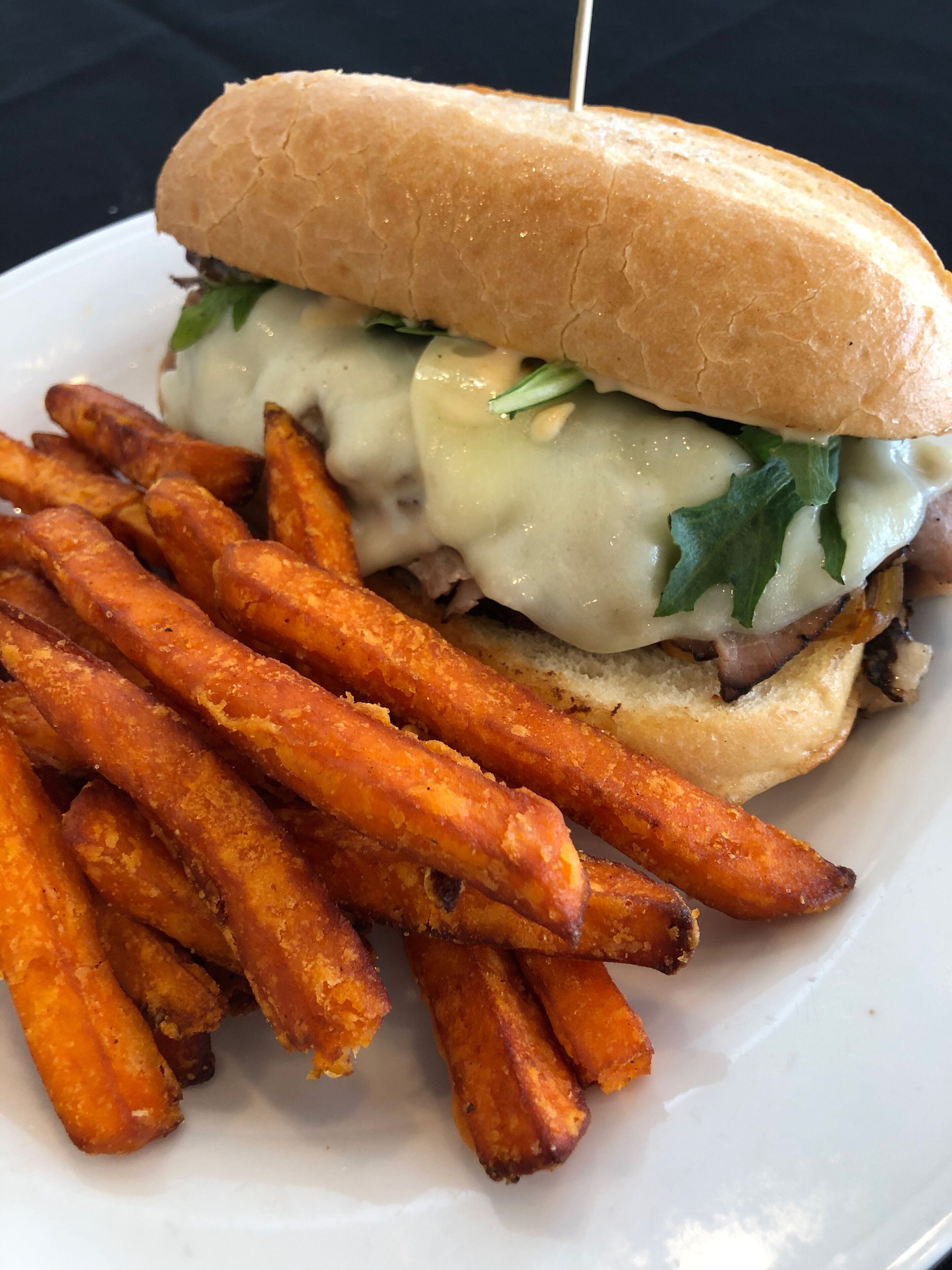 A sandwich with fries on a white plate.
