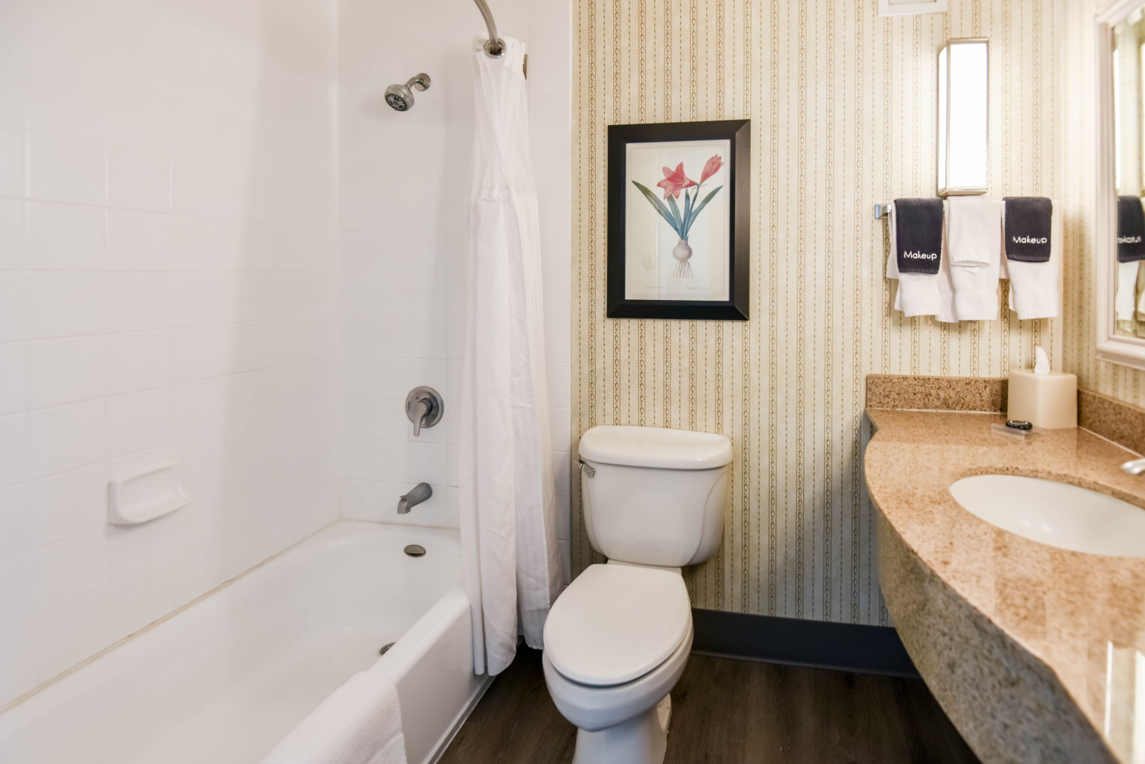A bathroom with a bathtub, toilet, and vanity with a sink.