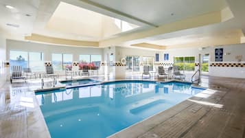 Una piscina techada, sillones reclinables de piscina