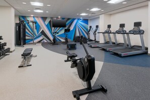 A gym with various exercise equipment including treadmills, stationary bikes, and weight machines. - Hilton Garden Inn Charlotte Uptown (Charlotte)