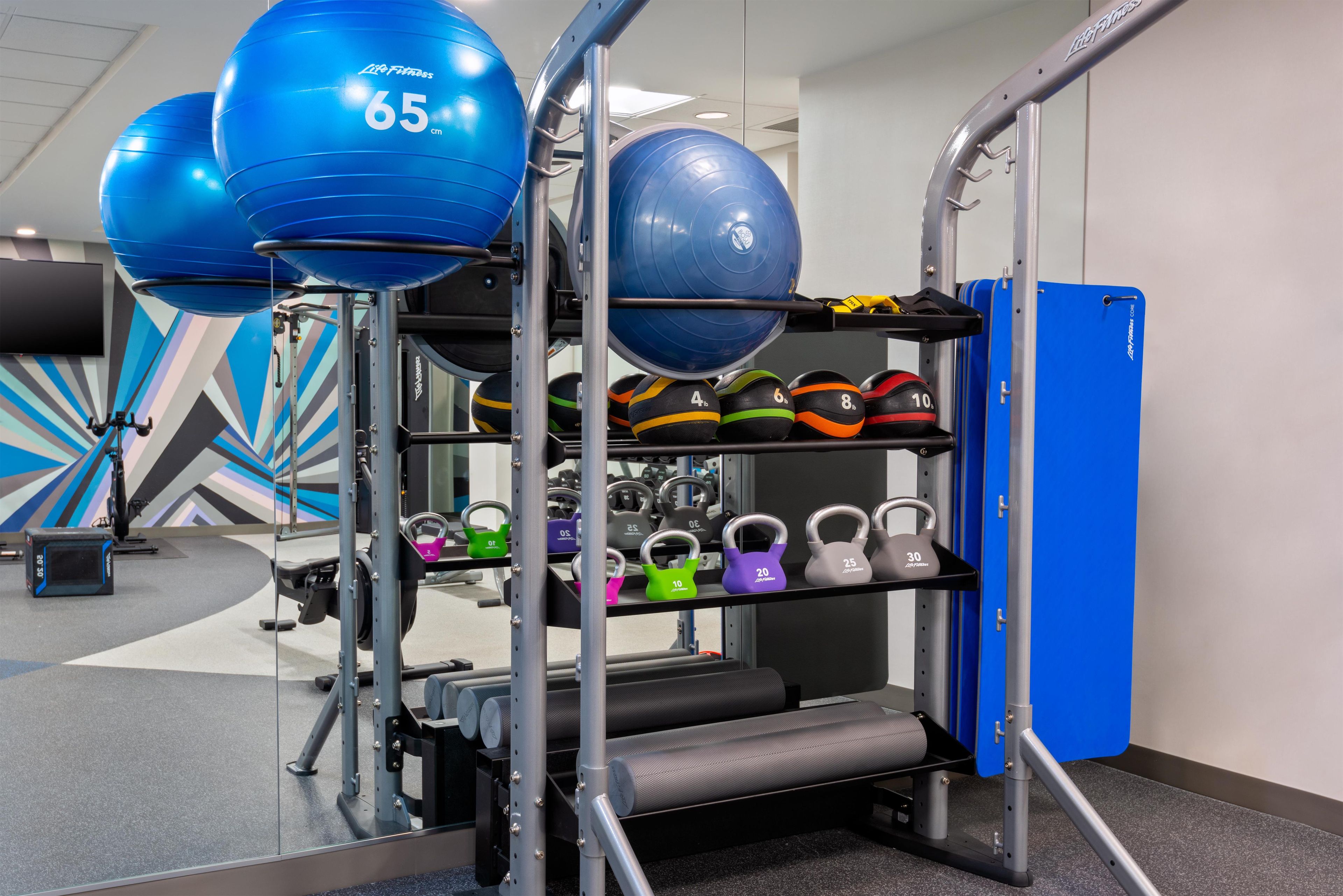 A gym with exercise equipment, including kettlebells and medicine balls.