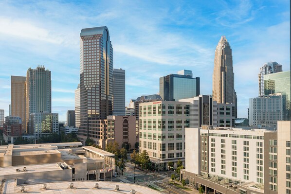 A cityscape with modern high-rise buildings, a clear sky, and a street with no visible pedestrians. - Hilton Garden Inn Charlotte Uptown (Charlotte)