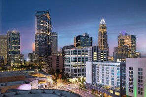 A cityscape at dusk with modern high-rise buildings, a well-lit intersection, and a clear sky. - Hilton Garden Inn Charlotte Uptown (Charlotte)