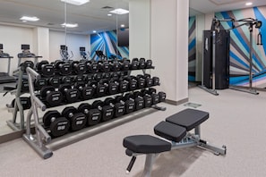 A gym with weightlifting equipment, treadmills, and a bench. - Hilton Garden Inn Charlotte Uptown (Charlotte)