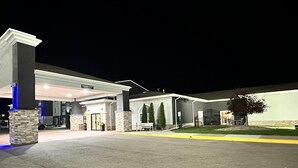 A hotel entrance with a covered parking area, stone pillars, and a sign indicating a clearance of 15 feet.