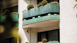 A multi-story building with balconies, each with a small round garden. - Hotel Central (Willingen)