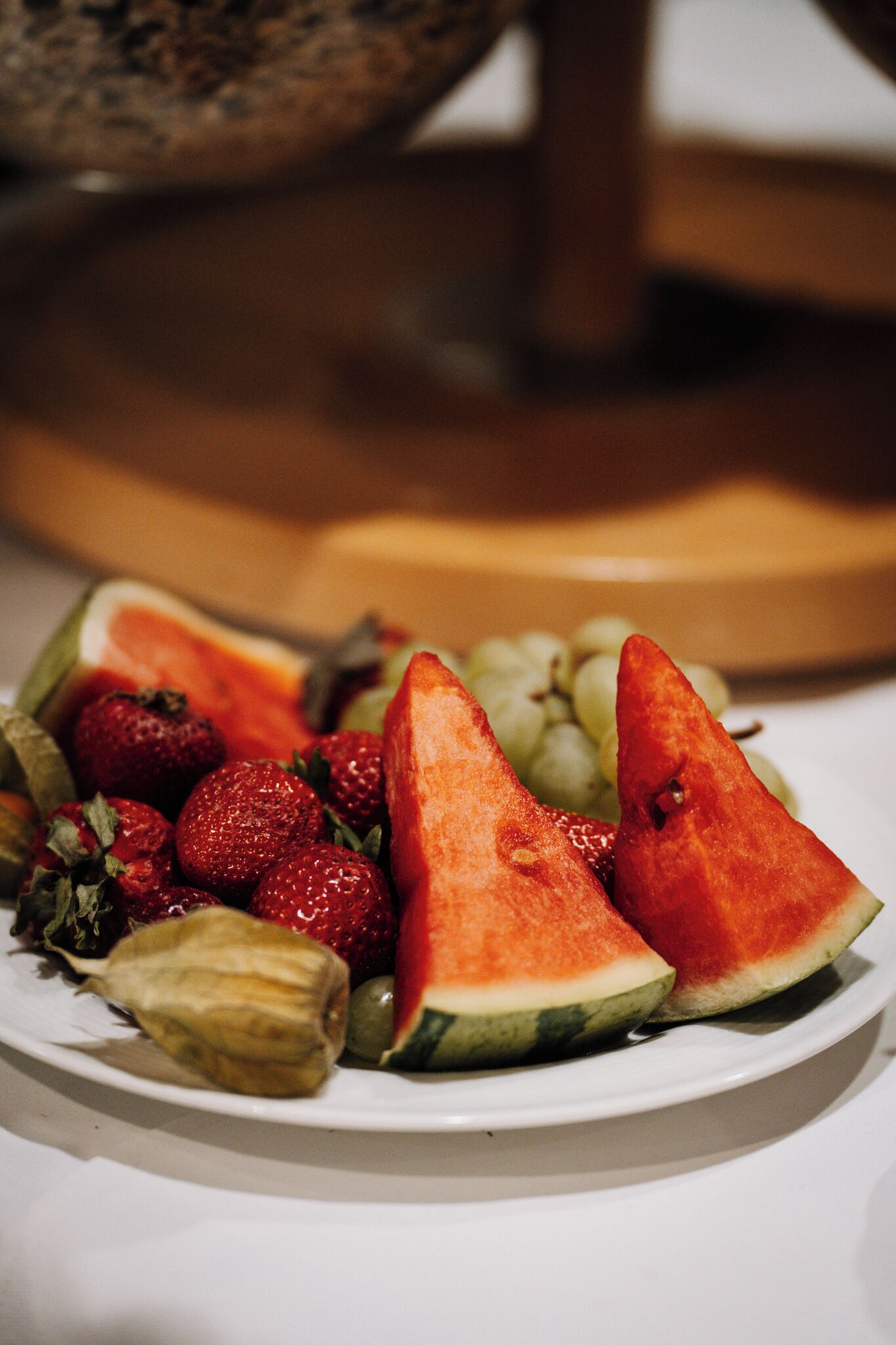 A plate of sliced watermelon, strawberries, and grapes.