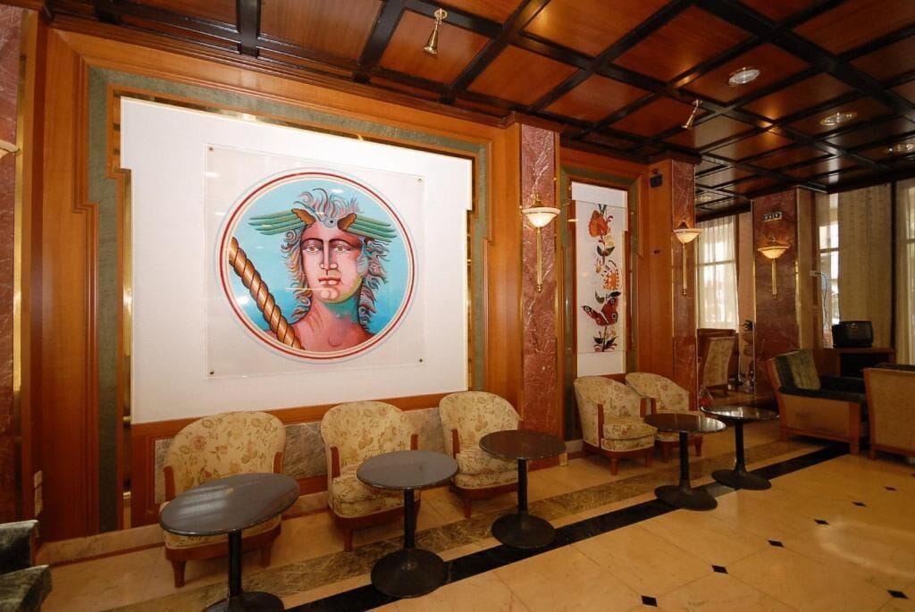 A lobby with a large mural, seating area, and a reception desk.
