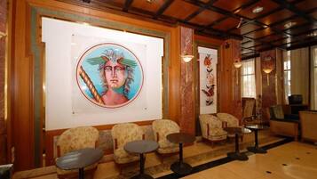 A lobby with a large mural, seating area, and a reception desk.