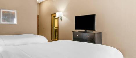 A hotel room with two beds, a flat-screen TV on a dresser, and a framed picture on the wall.