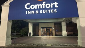 Placa da Comfort Inn & Suites com um logotipo em forma de crescente, fachada de tijolos e um conjunto de portas duplas.