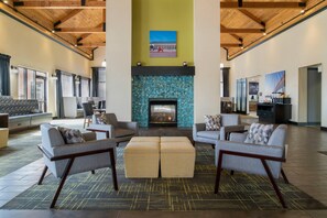A spacious lobby with a fireplace, seating area, and a view of the outside. - Comfort Inn & Suites Toledo North (Toledo)