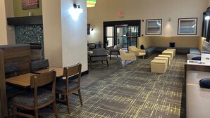 A modern interior with a seating area, a fireplace, and a patterned floor. - Comfort Inn & Suites Toledo North (Toledo)
